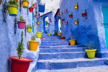 Afwasbaar Fotobehang Marokko Marokko, Chefchaouen of Chaouen staat vooral bekend om zijn kleine smalle straatjes en buurten die in verschillende levendige blauwe kleuren zijn geschilderd. Aanplant in kleurrijke potten langs de smalle gangen.