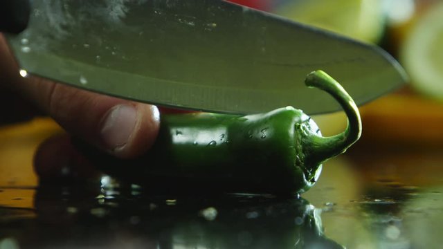 Slicing into a green jalapeno
