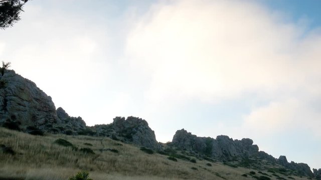 A time lapse of stratus and cumulus clouds emerging and changing as they move past a section of the Devils Backbone near Loveland Colorado. 4K