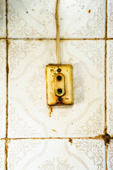Old rusty socket on dirty ceramic wall