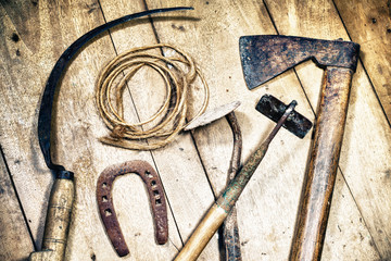 Different rustic tools on wooden floor