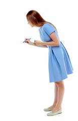 back view of writing beautiful woman. Isolated over white background. Skinny girl in a blue dress draws a felt-tip pen. side view