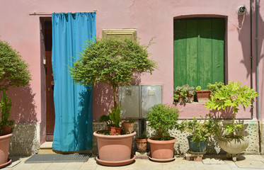 Fototapeta na wymiar A door covered by a cloth and a window in an historic building in Marano Lagunare in Friuli Venezia Giulia, north east Italy. 