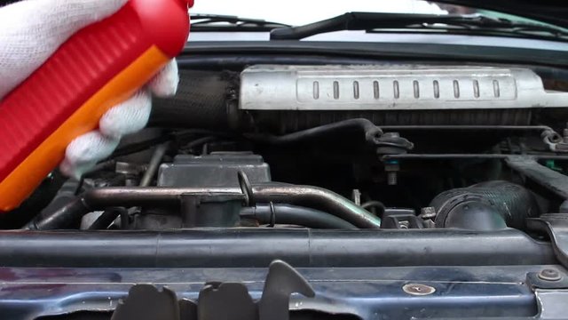 Mechanic Adding Coolant to Car radiators