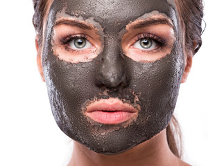 Beautiful woman with a clay or a mud mask on her face