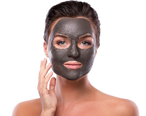 Beautiful woman with a clay or a mud mask on her face