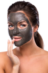 Beautiful woman with a clay or a mud mask on her face