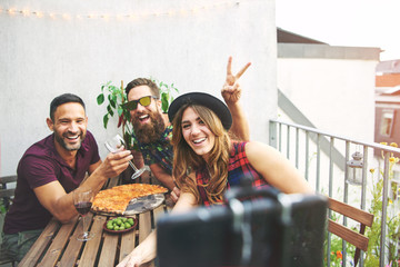 Rabbit ears gesture with friends at table