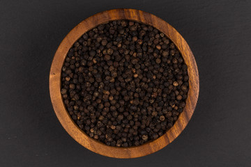 Black pepper in wooden bowl