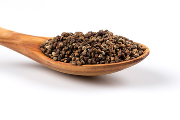 Decorticated cardamom seeds in a wooden spoon