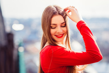 Dazzling girl in red dress looks over her shoulder