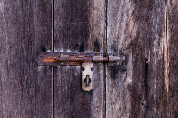 dusty bolt on grungy old wooden door.