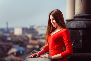 Elegant young woman looks confident while leaning over the stone