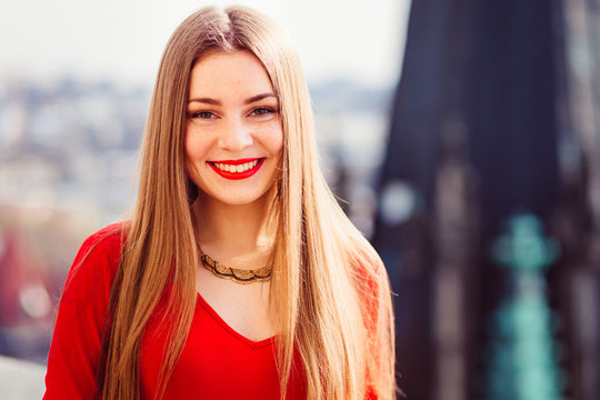 Bonny lady in red ress stands on the roof