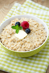 Oatmeal porridge in bowl with berries raspberries and blackberri