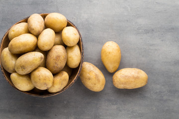 New potato on the bowl, gray background.