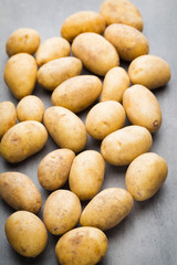 New potato on the bowl, gray background.