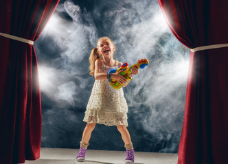 girl playing guitar on stage