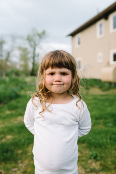 Portrait of young girl outdoors wearing white jumper