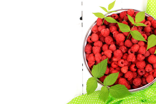 raspberries in a bowl on a white wooden background view from above a flat appearance