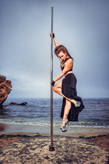Female pole dancer against the sea and sky
