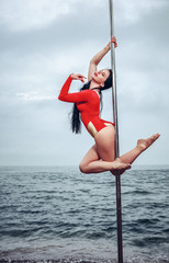 Female pole dancer against the sea and sky