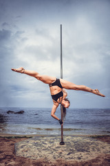 Female pole dancer against the sea and sky © Andriy Petrenko