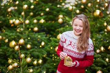 Young woman on a street of Paris decorated for Christmas