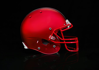Side view of a red football helmet on a black background