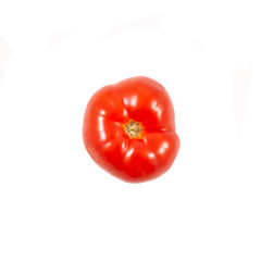 A tomato. Red tomato on a white background. Harvest vegetables. Autumn harvest. Red, juicy, ripe tomato.