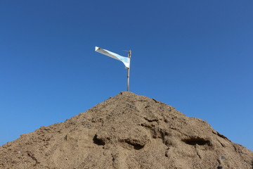 pyramid of sand with flag