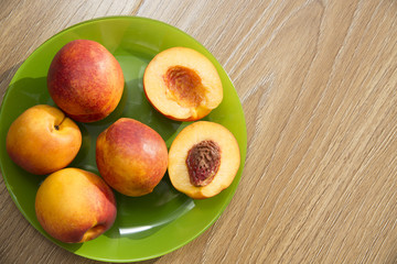 Healthy organic food, healthy fruits peaches. Ripe and tasty and juicy peaches lie on a plate on a wooden table