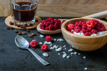 Tasty breakfast with cottage cheese, raspberries and cup of coffee.