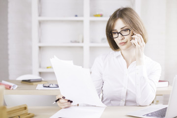 Woman on phone doing paperwork