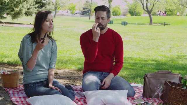 Couple smoking pipe in park