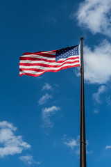 Looking Up at Waving American Flag on Cloudy Sky