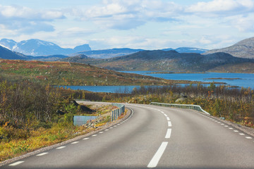Beautiful vibrant fall autumn landscape of national park near border of Finland, Sweden and Norway, with mountains, camping place, road and forest