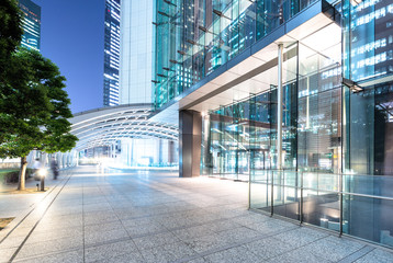 modern buildings in tokyo at night from empty footpath