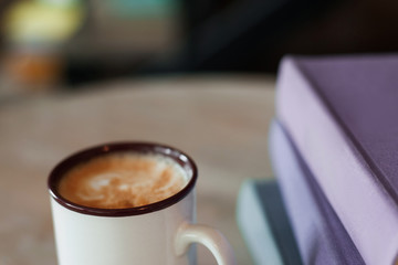 Cup of coffee with purple folders, free space. Working in office, coffee-break at workplace.