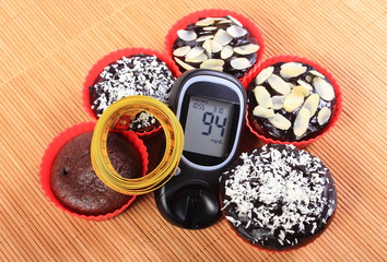 Glucometer, muffins in red cups and tape measure