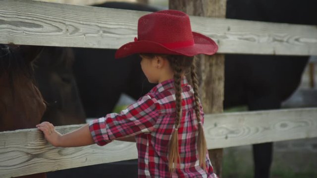 Young cowgirl looks at horses
