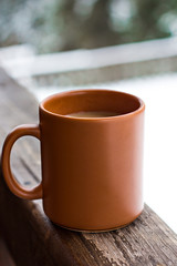 A cup with a hot drink on the background of the winter forest