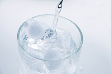 Pour water into a glass with ice.