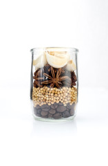 Garlic, star anise,coriander seed and coffee grains set up in glass jar on white background, seasoning ingredients for cooking.
