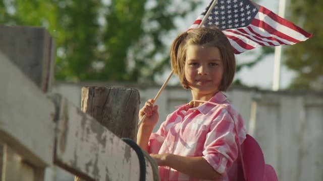 Portrait of young girl waving American flag