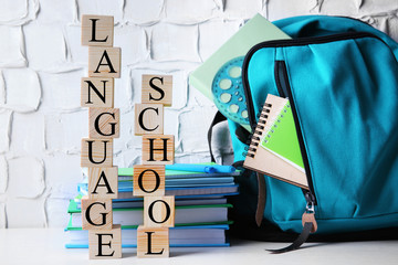 Words LANGUAGE SCHOOL with stationery set on light background