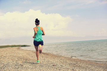 healthy young fitness woman trail runner running on seaside