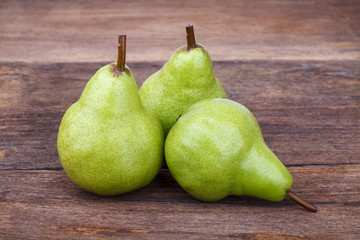 fresh green pears on old wooden table