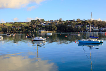 Fototapeta na wymiar Yachts moored in the Penryn River, looking across to Flushing from Falmouth, Cornwall, England, UK.