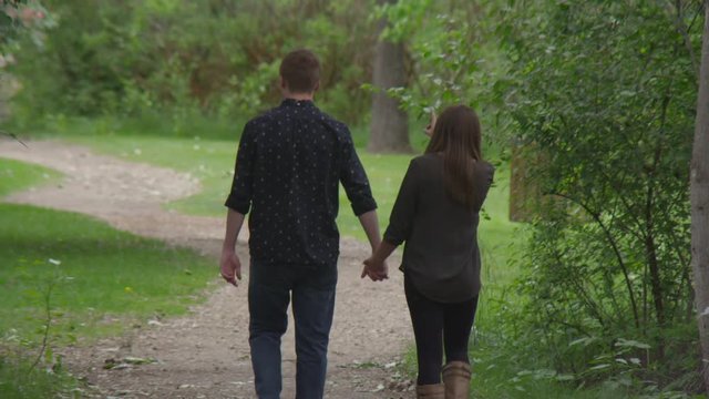 Young couple walking and holding hands in the park